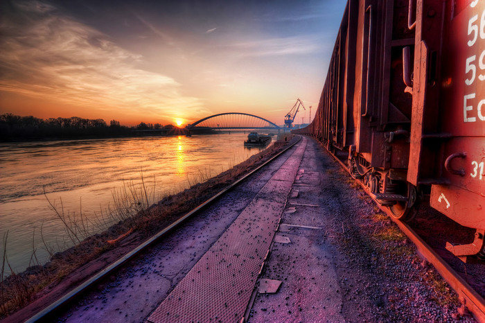 Long train running I took a little walk through the cargo port in Bratislava last weekend and I took a lot of shots :). As is visible on the photo, this was taken right at the sunset, which gave such nice colors to the photo. You can see the Apollo bridge in the distance with one of the port cranes. Btw. the title was inspired by the Doobie Brothers song :) HDR from three shots, taken with Canon 450D with Sigma 10-20mm lens, from a tripod.